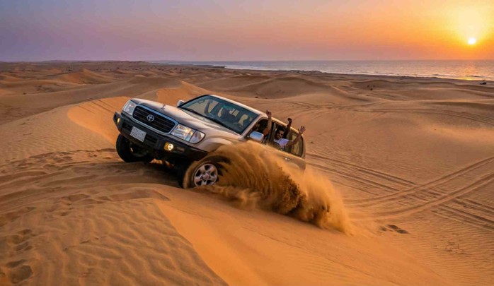A Toyota Land Cruiser 4x4 vehicle is kicking up a large cloud of sand while dune bashing in Jeddah's desert dunes at sunset, with the sea visible in the background.