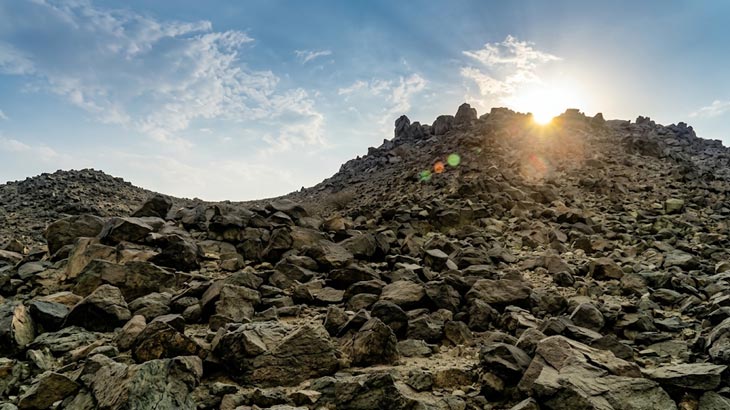 Sun rising over the rugged boulder-strewn hills of New Moon Valley near Jeddah.