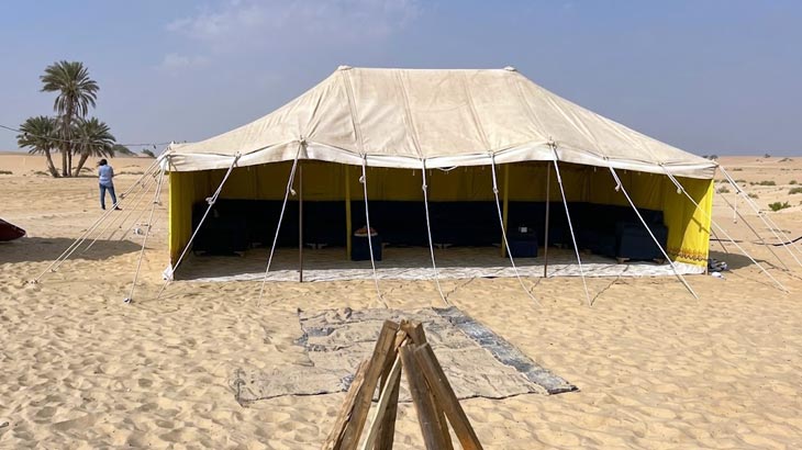 Large traditional desert tent rental in Jeddah with shaded outdoor seating and campfire setup.