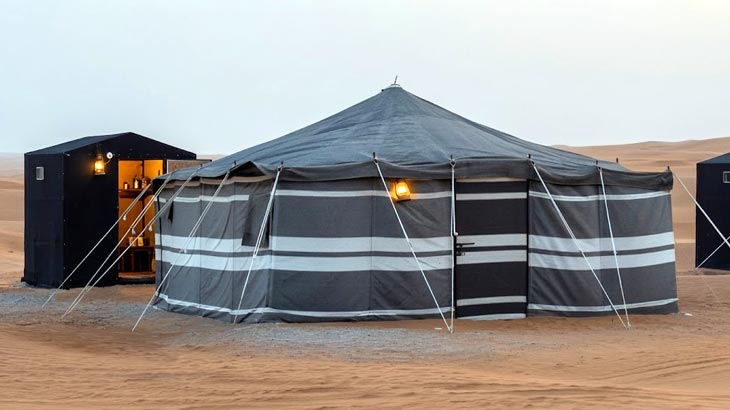 Traditional black and white striped Bedouin tent setup available for rent in the Jeddah desert.