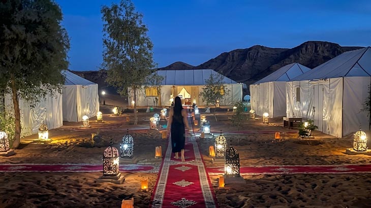 Private desert camp resort in Jeddah with illuminated carpeted pathway and overnight tents.